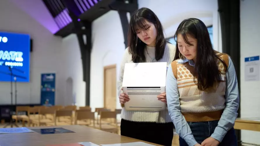 two girls looking at business model canvas documents on a table