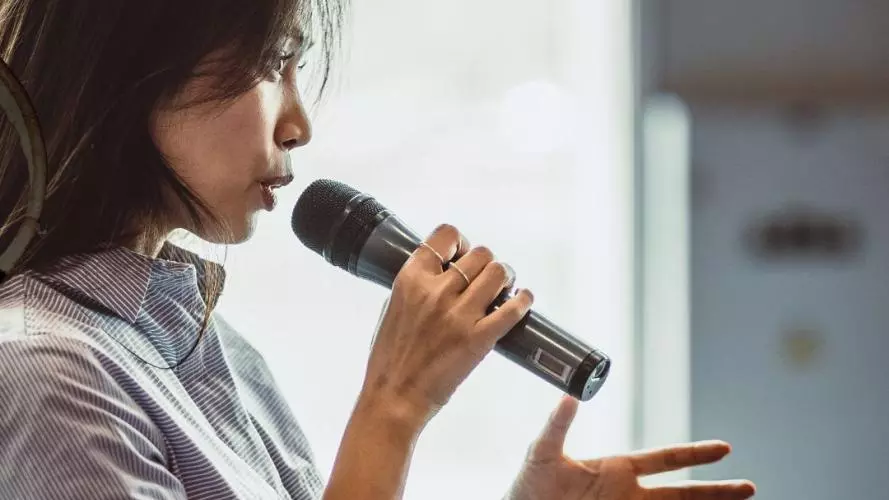 A Woman pitching with a microphone