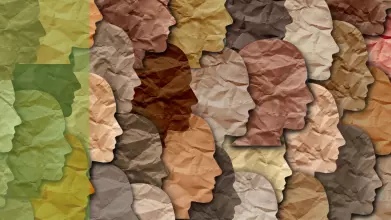 Cut out pieces of paper in the shapes of faces in various shades