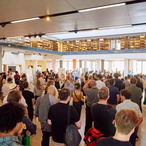 A crowd at an event listening to a speaker
