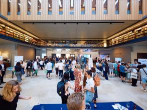 A wide shot of the Weston Library During Demo Night 2023 showing the startup stands and crowd members