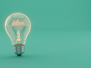 A lightbulb on a plain blue background with the word 'idea' spelt out as filament