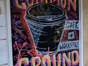 A chalk board sign with a coffee cup illustration and Common Ground typography