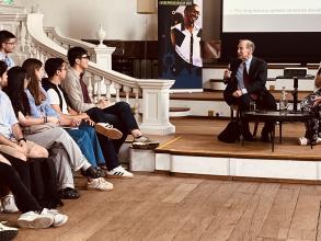 Speakers sat in front of an audience talking at an event