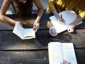 Birds eye view of three students working at a table with open books
