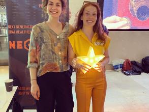 Demo Night 2023 second place winners, Vitaegum stood next to their stand holding a trophy