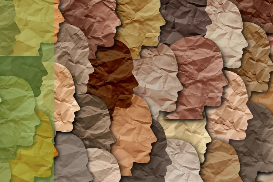Cut out pieces of paper in the shapes of faces in various shades