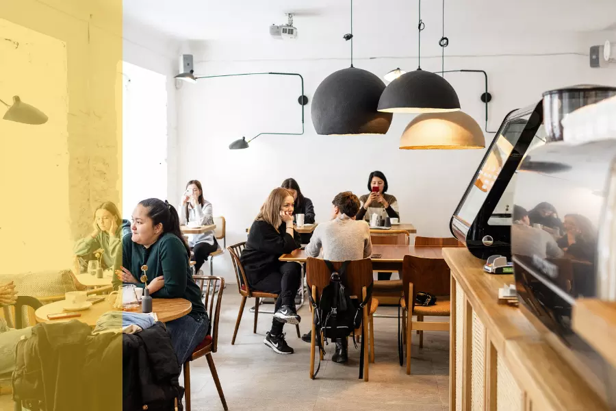 A cafe scene with groups of people sat at tables