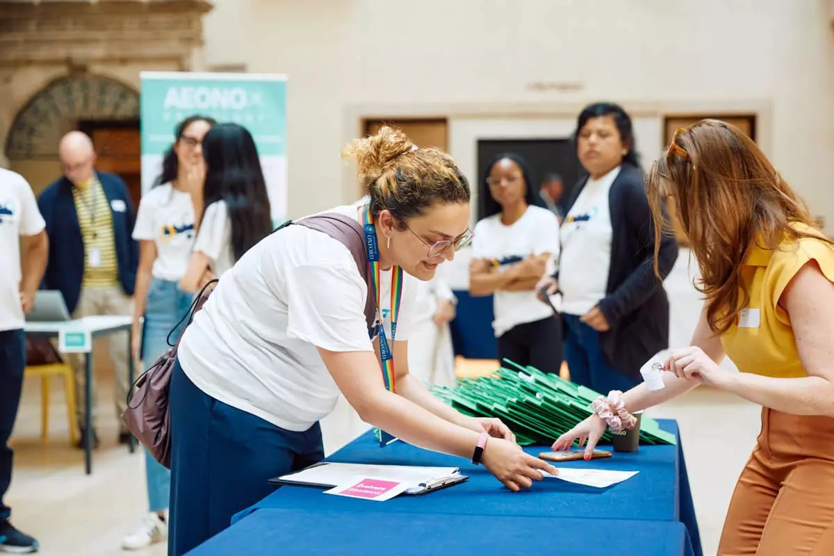 A women at a desk signing in an attendee at an event