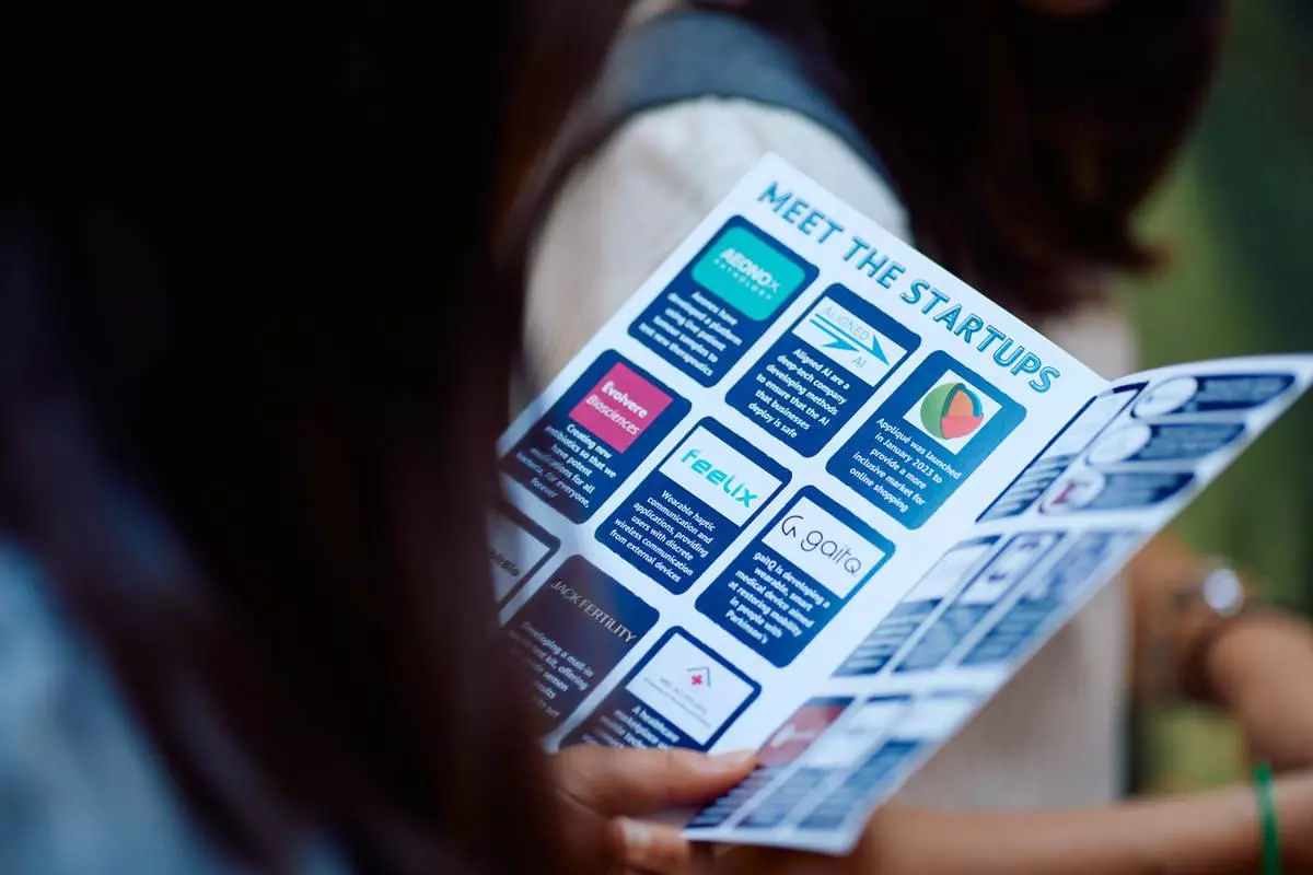 A woman reading a 'meet the startups' brochure