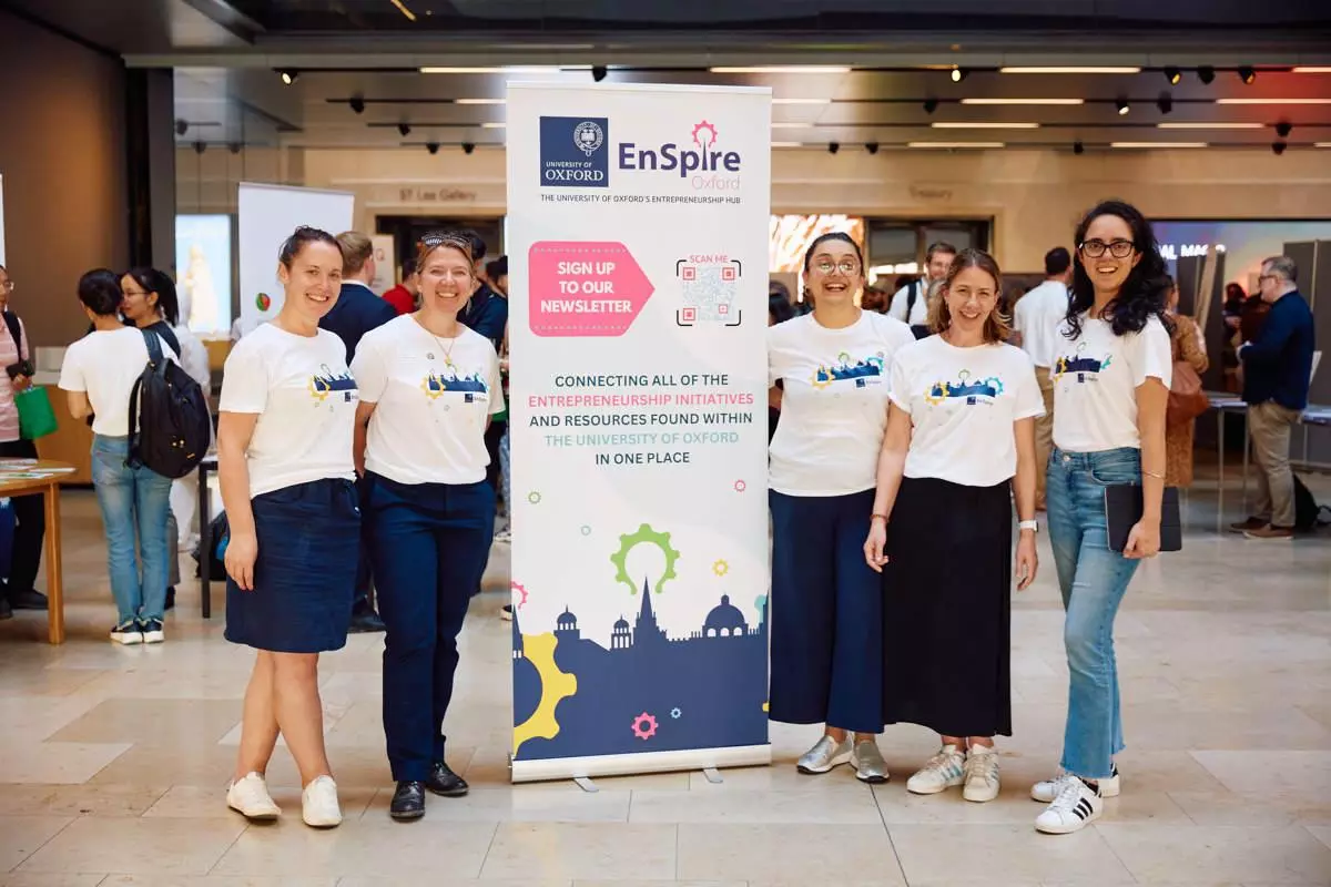 The EnSpire team stood next to an EnSpire banner at an event