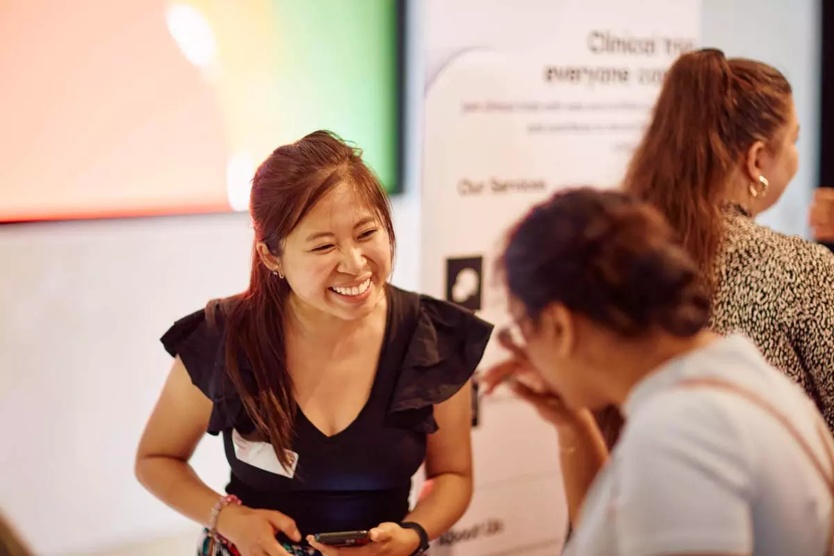 A women smiling and chatting to another women at an event