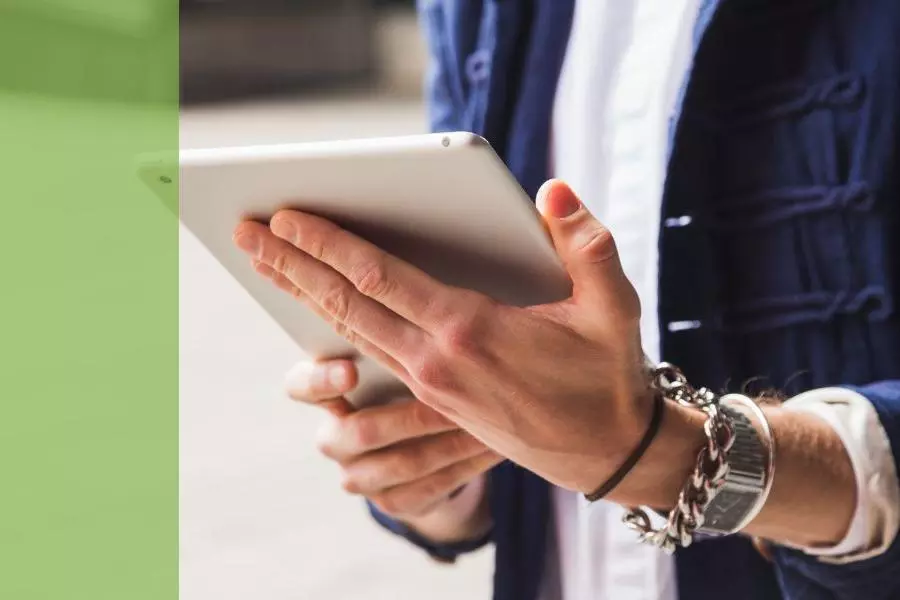 A man holding and looking at an ipad