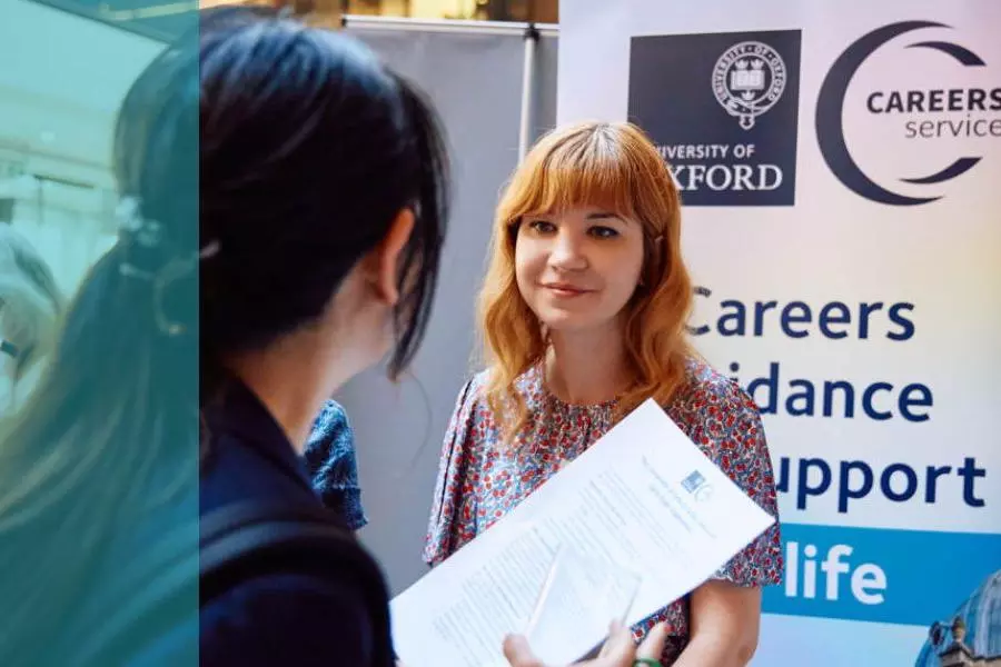 A woman at an event talking about careers advice to an attendee